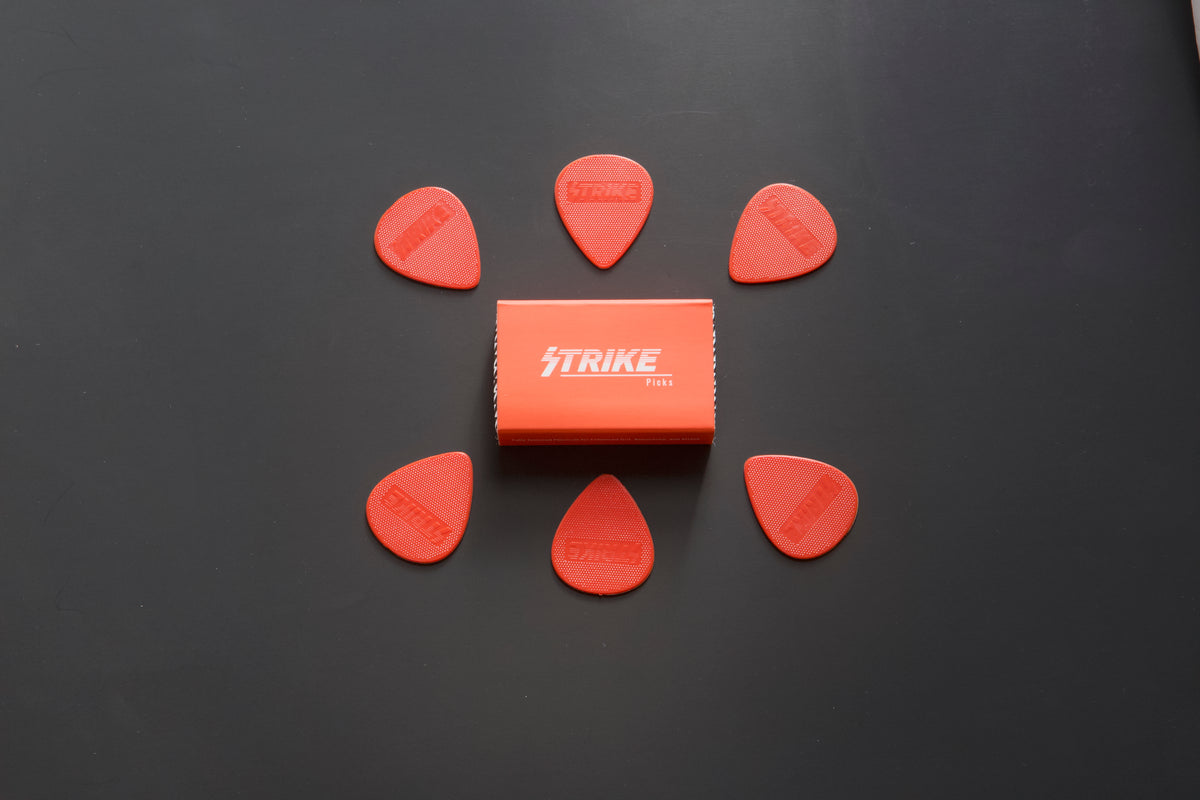 Strike Picks red guitar picks arranged around branded box